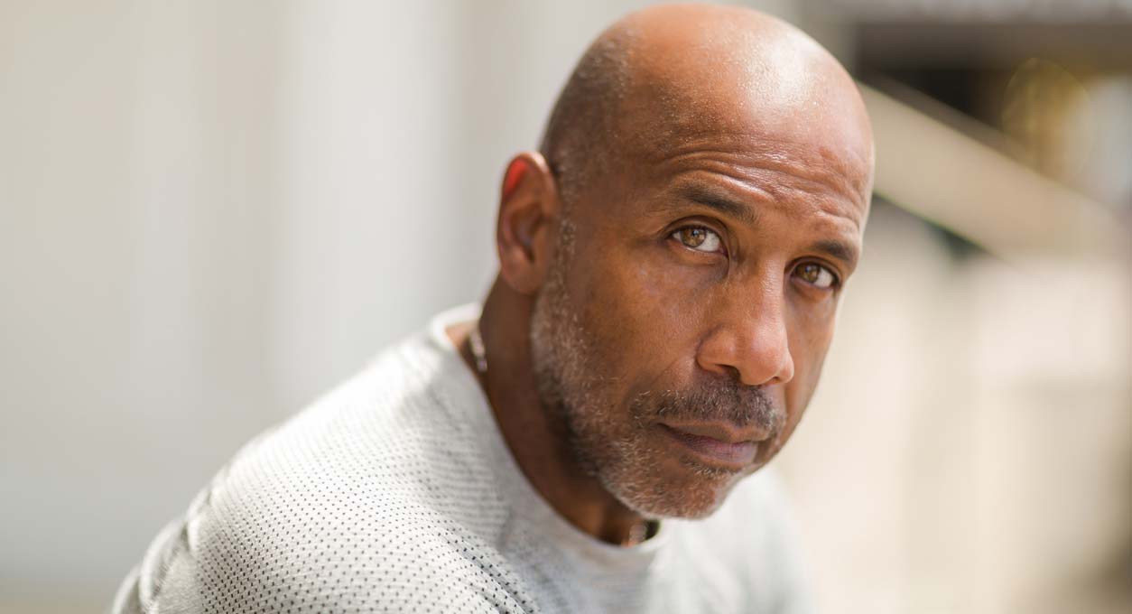 An older African American man wearing a white shirt.
