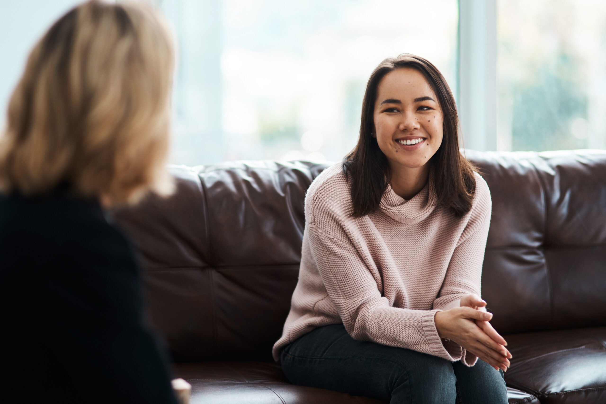Smiling woman engaging in a positive recovery discussion with a therapist.