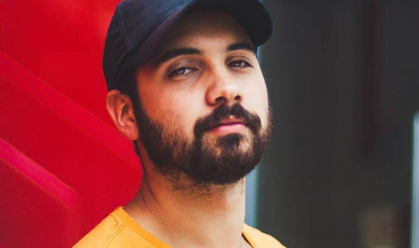 A young man wears a ball cap.